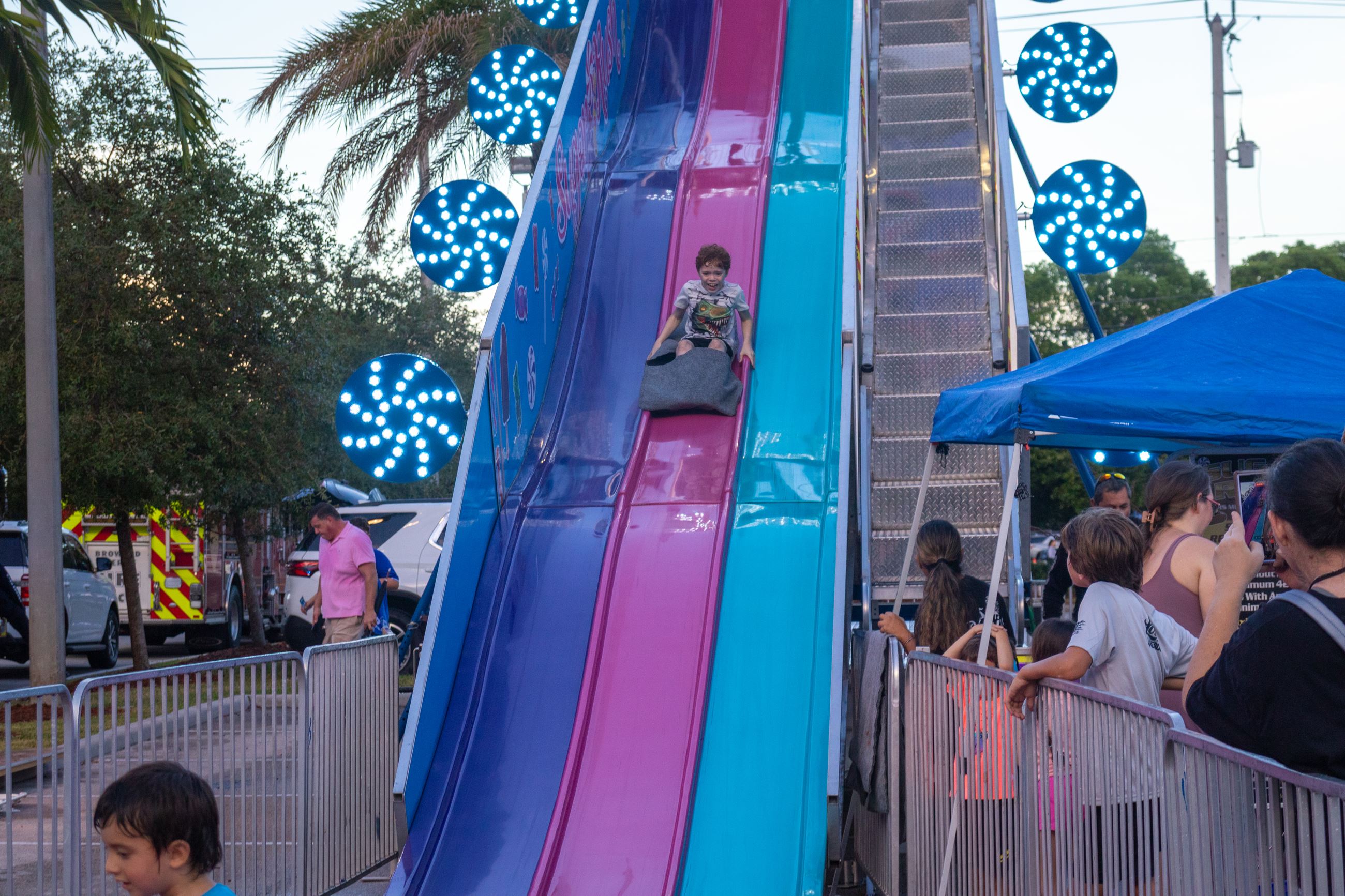 A child going down a slide at sunset