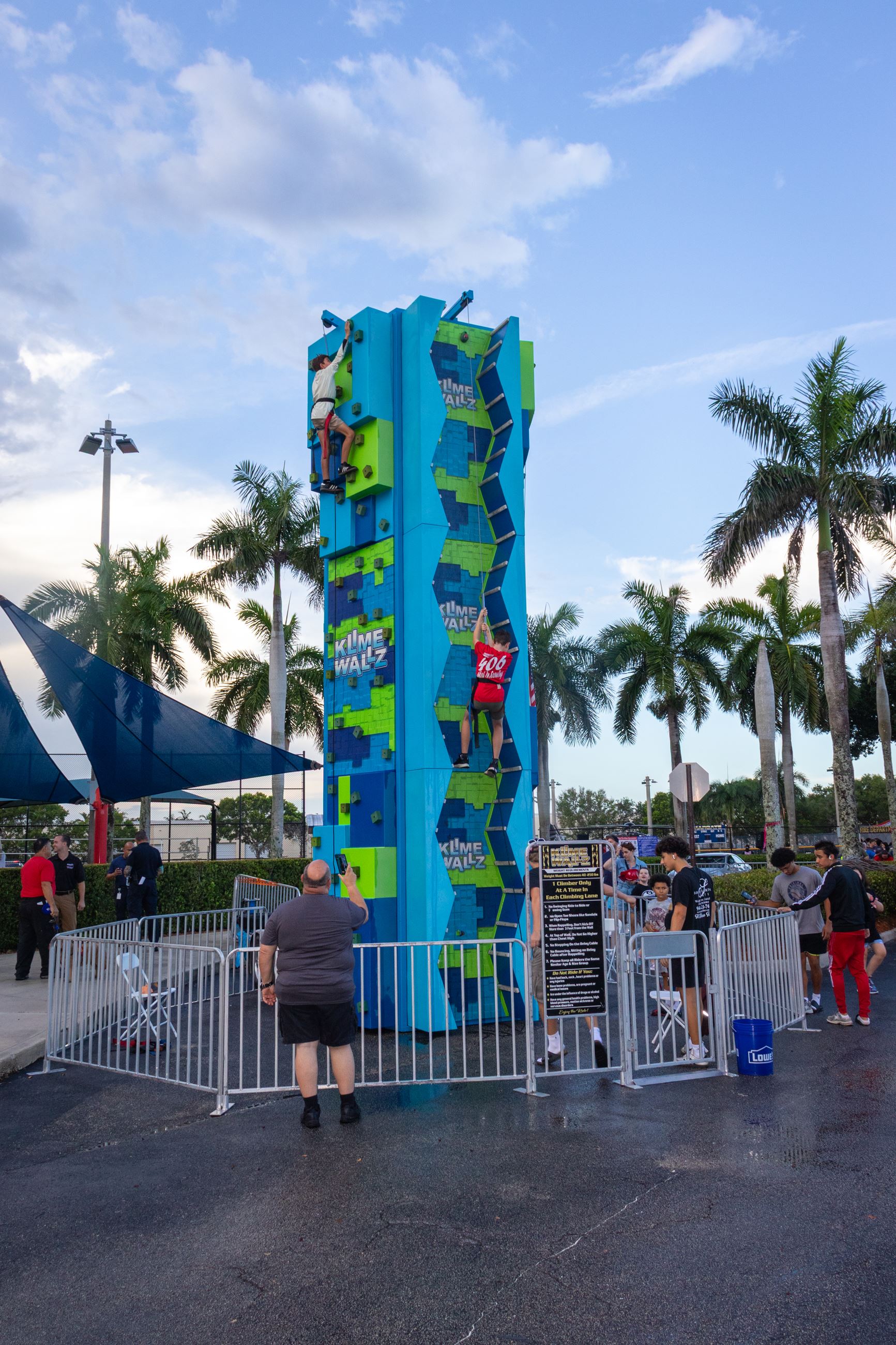 Two attendees climb a rock wall