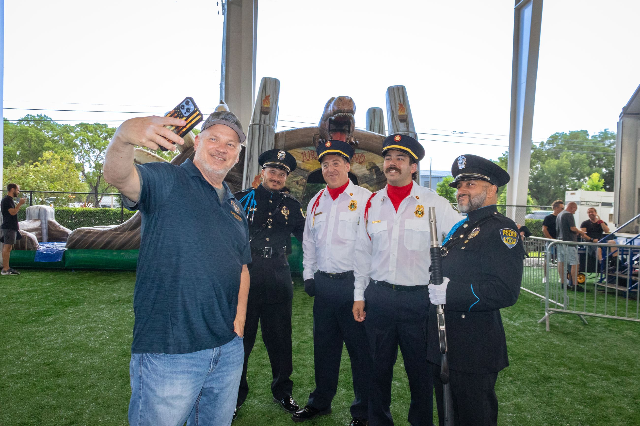 An attendee poses for a selfie with the Police and Fire Honor Guard